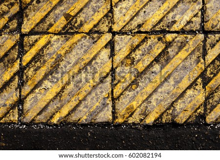 Texture of dirty pedestrian yellow road tiles with reagents