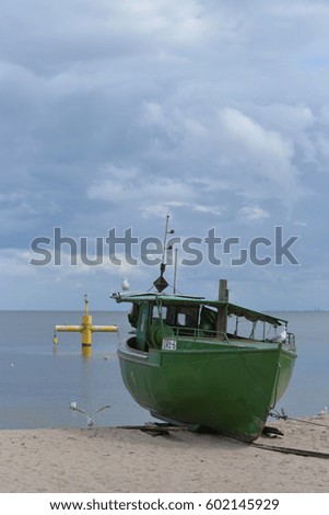 Green keel boat with blue sky and blue ocean in the background.
