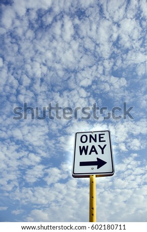 One Way Street Sign with Dramatic Blue Sky and White Clouds