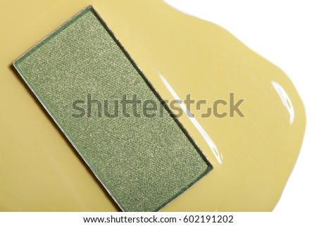 Green eye shadow and yellow nail polish.