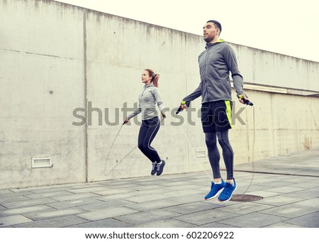 fitness, sport, people, exercising and lifestyle concept - man and woman skipping with jump rope outdoors Royalty-Free Stock Photo #602206922