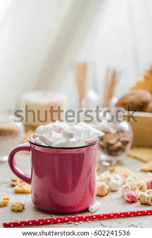 a delicious Cup of cocoa with marshmallows and straws in polka dots, sweets on a light wooden background,concept drinks and relaxing weekend