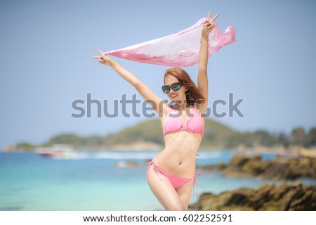 woman enjoy on the beach with holding a piece of shroud over the head 