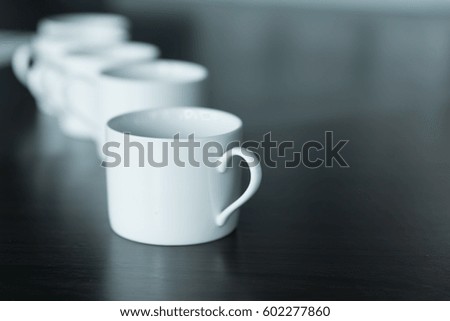 Many cups of coffee on wooden table 