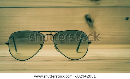 Sunglasses on wooden table. Photo in retro color image style.
