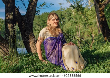 Beautiful european woman in traditional indian sari near the lake