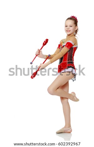 Cute little girl gymnast in a beautiful costume for competition, performs exercises with mace.Isolated on white background.