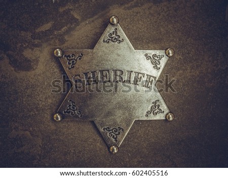 Sheriff badge on natural stone background. Macro shot.