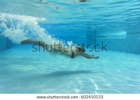 Woman in bikini at swimming pool underwater 
