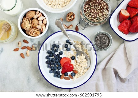 Power breakfast ingredients for preparing of overnight oats with fresh berries and  various of super foods topping.