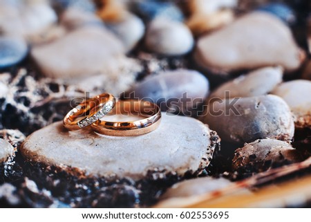 Wedding rings with a diamond lie on a stone