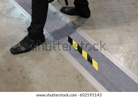 Man cross yellow and black stripe warning 