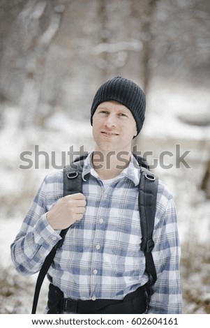 A hiker in the mountains with a rucksack and a woolly hat