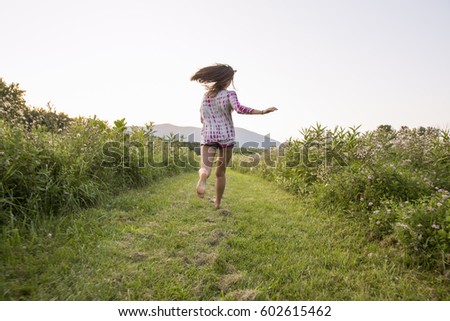 A woman running along a path in a meadow