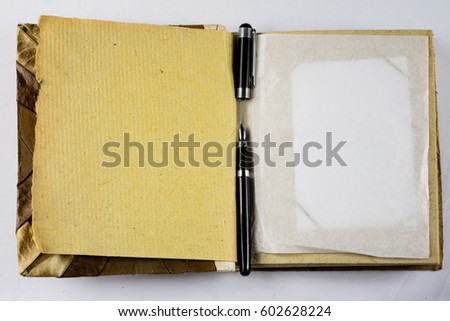 Old photo album on a white background with pen and pencil