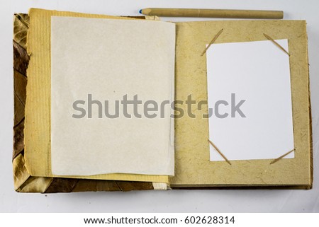 Old photo album on a white background with pen and pencil
