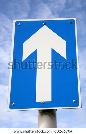 White one way traffic sign against blue sky background