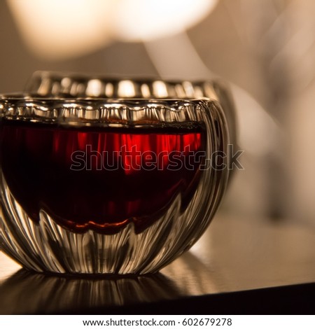Black tea in a glass transparent bowls. Few small cups of tea on table. Glass piala with double walls, double-bottomed bowl. Meal, aperitif, repast. Square. Blurred background