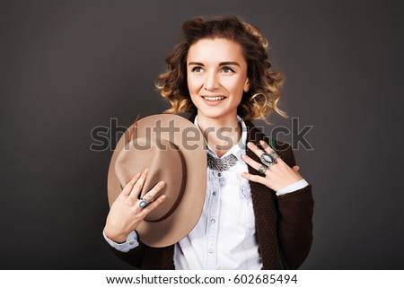 Close up portrait of beautiful woman which holding a hat,bohho style,beauty make up, amazing boho look,Rings,great details,curly hair,denim shirt,red lips,European,Well-groomed skin,Beautiful big eyes