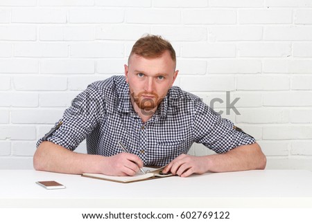 Business or freelance concept. Businessman sitting at the table and working on the computer. It solves important business tasks. He is successful and well-trained. He alone on a white background.