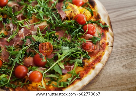 Fresh baked pizza with cherry tomato ham rucola , homemade prepared food.