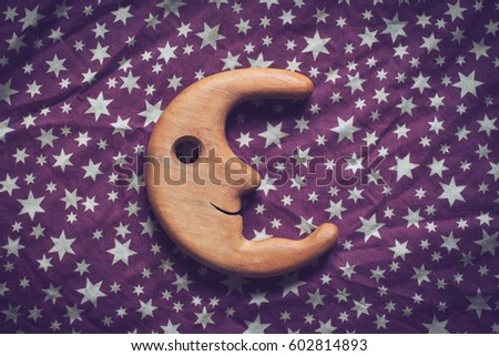 top view concept wrinkled background texture of purple textile table cloth with white stars and wooden toy moon smiling in the center