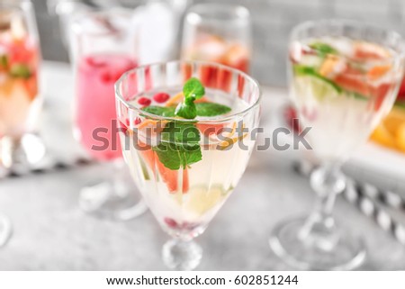 Glass of delicious wine spritzer on grey table