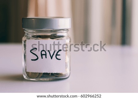 money in the glass with the word 'SAVE' written