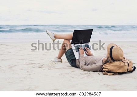 Young woman working, using laptop computer on a beach. Freelance work, vacations, distance work, social distancing, e-learning, connection, creative professional, new business, meeting online concept Royalty-Free Stock Photo #602984567