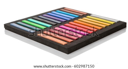 Chalk pastel stick in black container box over white background