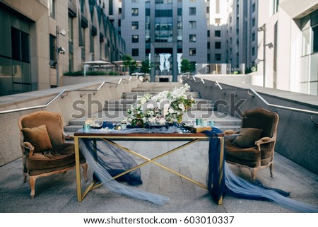 Beautiful decoration for a dinner with white flowers, two easy chairs and wood table