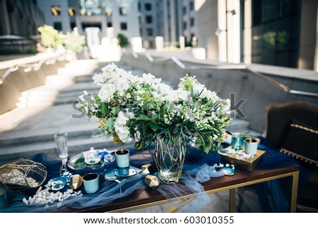 Beautiful decoration for a dinner with white flowers, two easy chairs and wood table