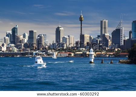 sydney australia CBD close-up with lighthouse and boat in harbour water blue sky skyscrapers