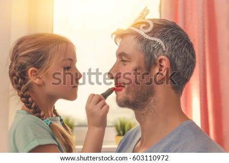 dad with cute daughter beeing treated with lipstick for carnival Royalty-Free Stock Photo #603110972