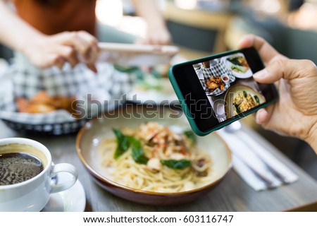 Friends taking photo on dish in restaurant
