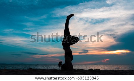 Silhouette of a woman playing yoga on twilight. Sunset sky background