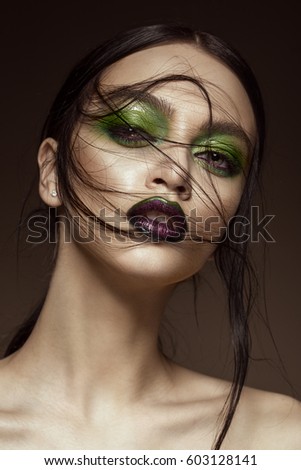 Beautiful girl with spring green makeup and vampire lips. beauty face. Photos shot in studio