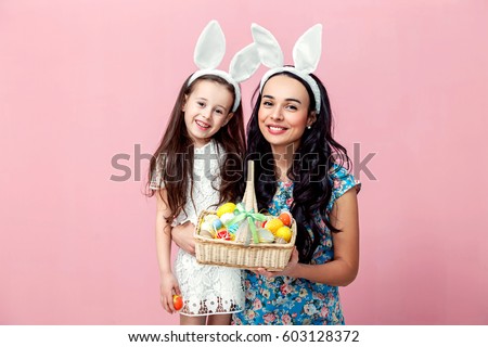 easter, family, holiday and child concept - close up portrait of little girl and mother coloring eggs for easter. Royalty-Free Stock Photo #603128372