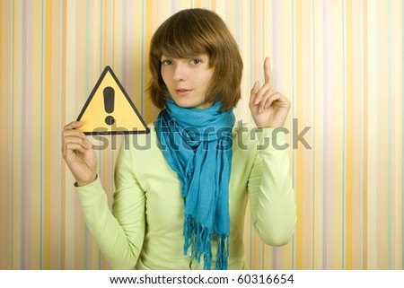 Beautiful girl with a yellow card with an exclamation point a finger raised upward