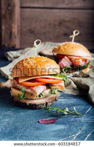 Burger with bacon, arugula, tomatoes and cheese