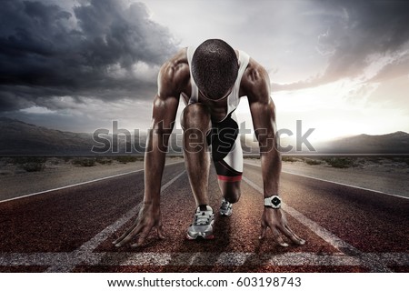Sport backgrounds. Sprinter on the start line of the track befor the dramatic sky. Royalty-Free Stock Photo #603198743