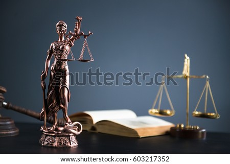 Law and Justice concept. Mallet of the judge, books, scales of justice. Gray stone background, reflections on the floor, place for typography. Courtroom theme.