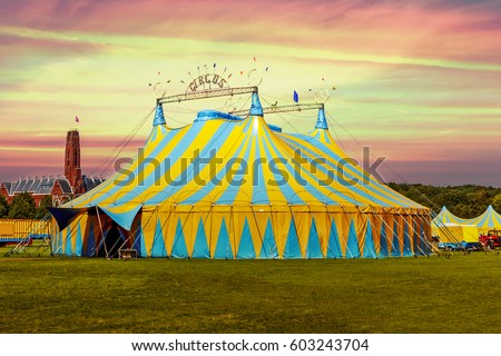 Circus tent under a warn sunset and chaotic sky without the name of the circus company which is cloned out and replaced by the metallic structure Royalty-Free Stock Photo #603243704