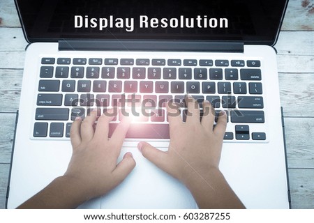 Hand on keyboard with flare effect and text DISPLAY RESOLUTION, information, connection, communication, and technology concept