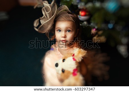 Portrait little girl at Christmas.
Child with Christmas tree background