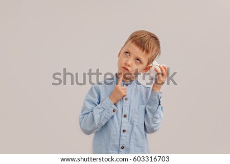 Cute little boy holding a piggy bank or money box. Concept child and money.