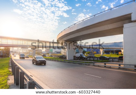 Highway interchange with bridge on the background Royalty-Free Stock Photo #603327440