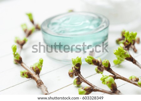white moisturizer and blue cosmetic gel samples on white wood table