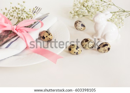 Elegance table setting with pink ribbon and flower on white background. Easter romantic dinner. Top view and copy space.
