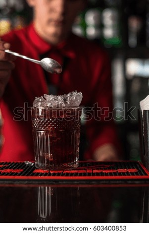 Cocktail on the bar. The barman is preparing an alcoholic drink close up.